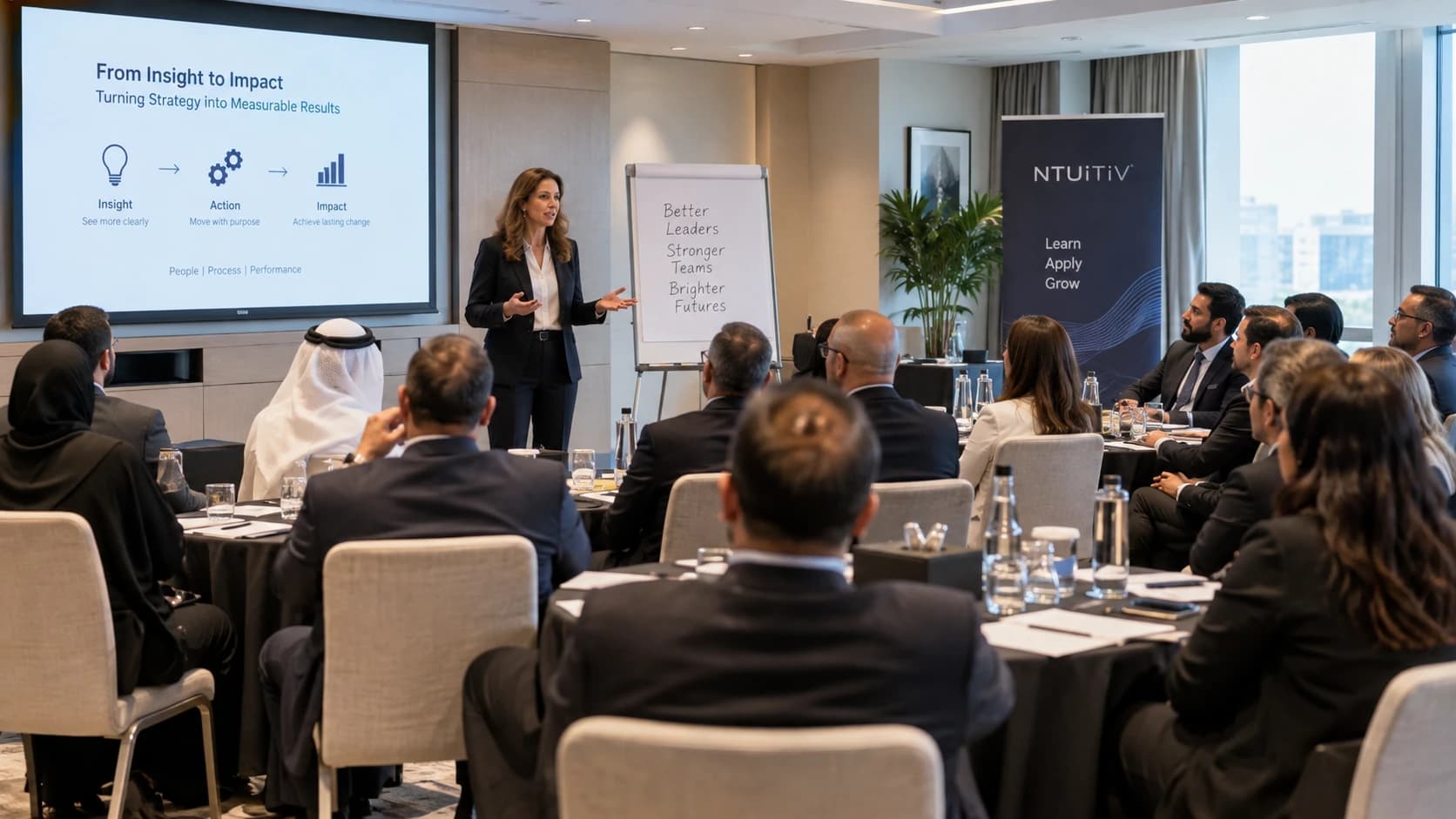 NTUiTiV in-company training session with a presenter addressing delegates beside a flipchart reading Better Leaders, Stronger Teams, Brighter Futures